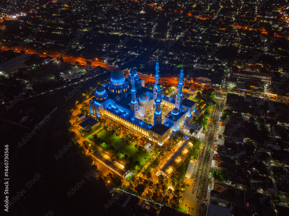 Fototapeta premium Aerial Night View of Sheikh Zayed Grand Mosque in Solo, Central Java, Indonesia Illuminated with Blue Lights Surrounded by Cityscape