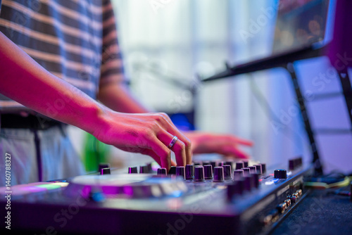 Close up of man artist DJ mixing and scratching music mixer controller.
