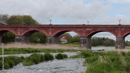 Kuldiga, Latvia Water flowing in  the Venta River and the famous red brick bridge.