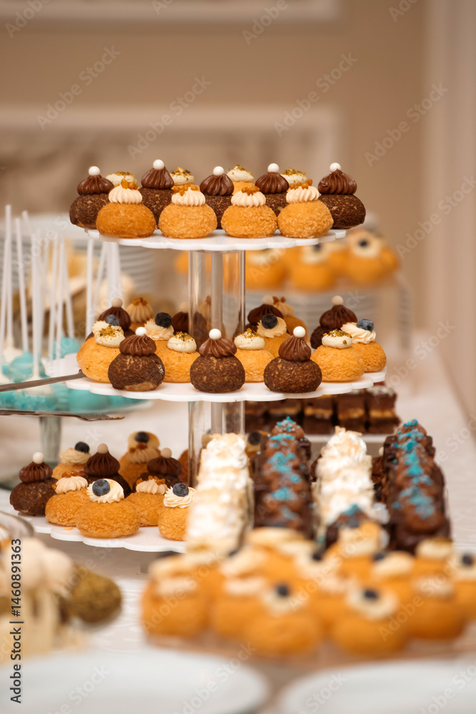 Different kinds of beautiful pastry, small colorful sweet cakes, macaron, and other dessert in the sweet buffet