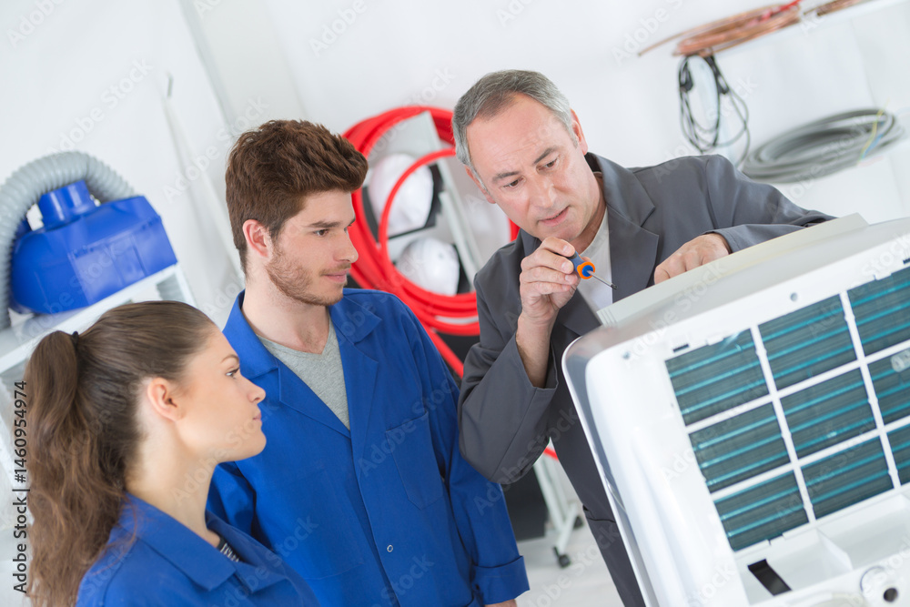 apprentices learning to repair industrial air conditioning