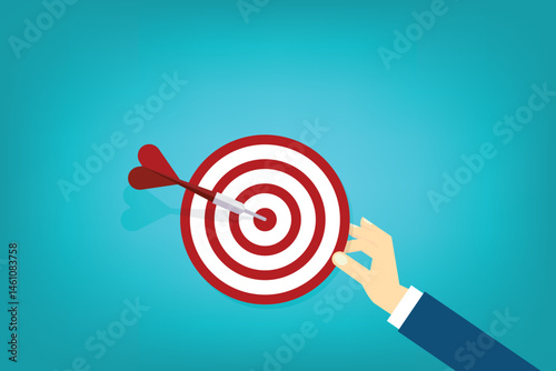 Hand holding a target, showing a goal. Red arrow hits the center. Business challenge failure and success concept.