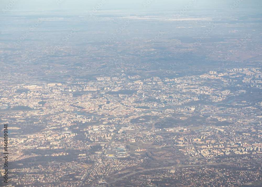 Plane window view of snow Polish fields and villages, Krakow suburbs, aircraft fly landscape