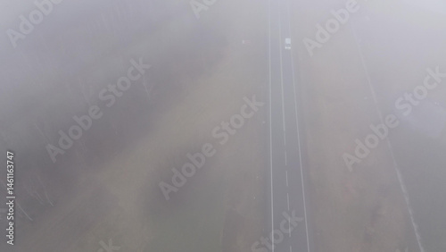 Car traveling on misty road in low visibility