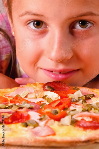 Portrait of happy young girl with pizza. Vertical image.