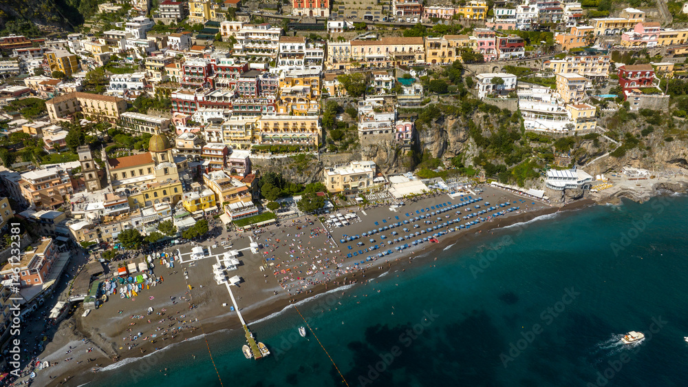 Aerial view of the beach and the city of Positano in the province of Salerno, Campania, Italy. The colorful houses of the town overlook the Mediterranean Sea. It is a beautiful tourist destination.