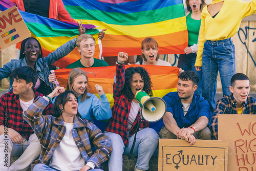 Young activists protesting for equality and lgbtq+ rights with rainbow flags and megaphone