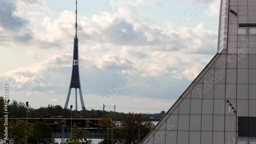 Riga, Latvia A commuter train crosses the Daugava River on the Railway Bridge and the TV Tower. 