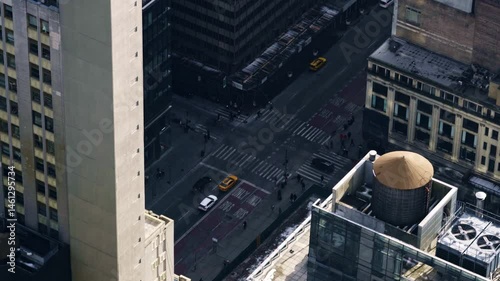 Inclined top down bird's eye view of a typical Manhattan intersection as traffic and pedestrians travel on the streets below.