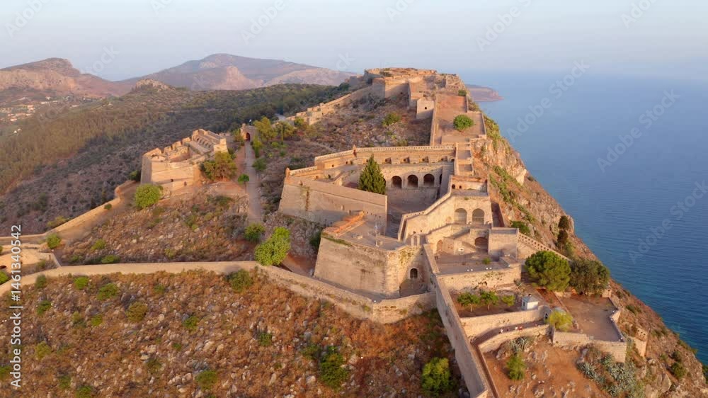 4k drone flight point of view (Ultra High Definition) of fortress of Palamidi. Spectacular evening view of Peloponnese peninsula, Greece, Europe. Colorful cityscape of old town of Nafplion port.