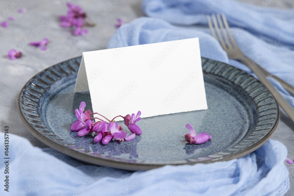 Wedding table place with folded card near wild purple flowers and fabric closeup, mockup