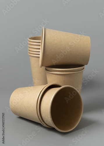 Obraz na płótnie Disposable beige kraft paper cups on a gray closeup, mockup. No plastic and sustainable lifestyle w salonie