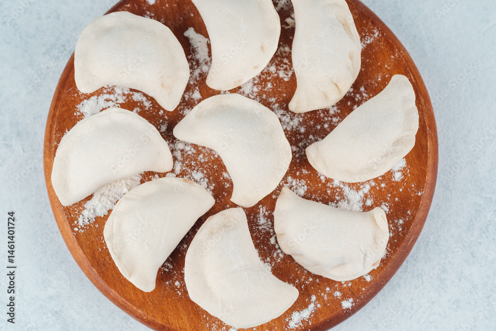 Preparing homemade dumplings on a wooden board in a kitchen setting