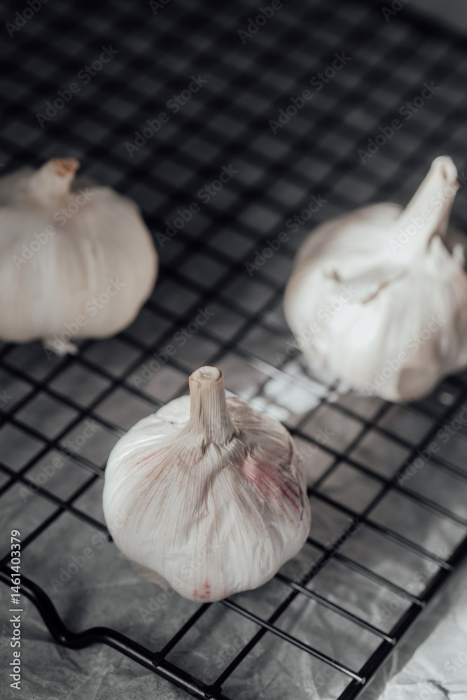 Fresh garlic bulbs resting on a wire rack after being harvested