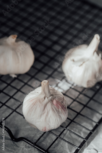 Obraz na płótnie Fresh garlic bulbs resting on a wire rack after being harvested w salonie