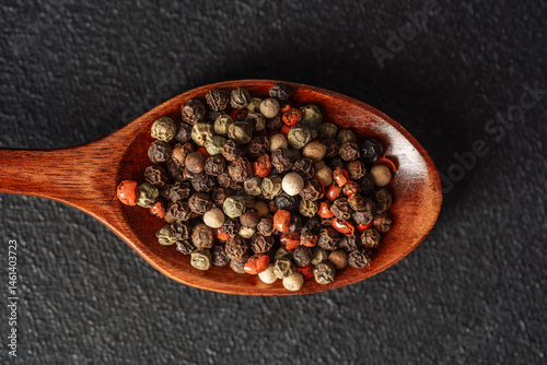 Obraz na płótnie Variety of spices displayed on a wooden spoon on a dark background w salonie
