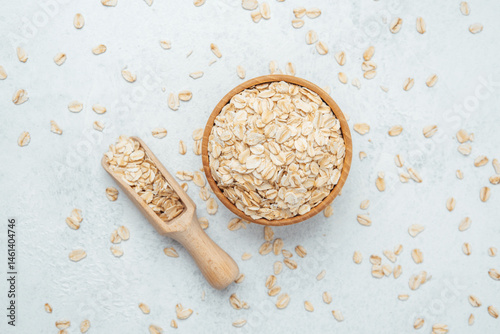 Obraz na płótnie Healthy oats in a wooden bowl with a scoop on a light background w salonie