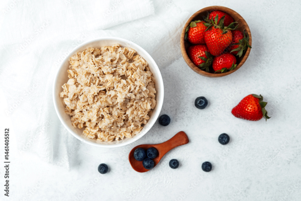 Creamy oatmeal topped with fresh strawberries and blueberries for breakfast