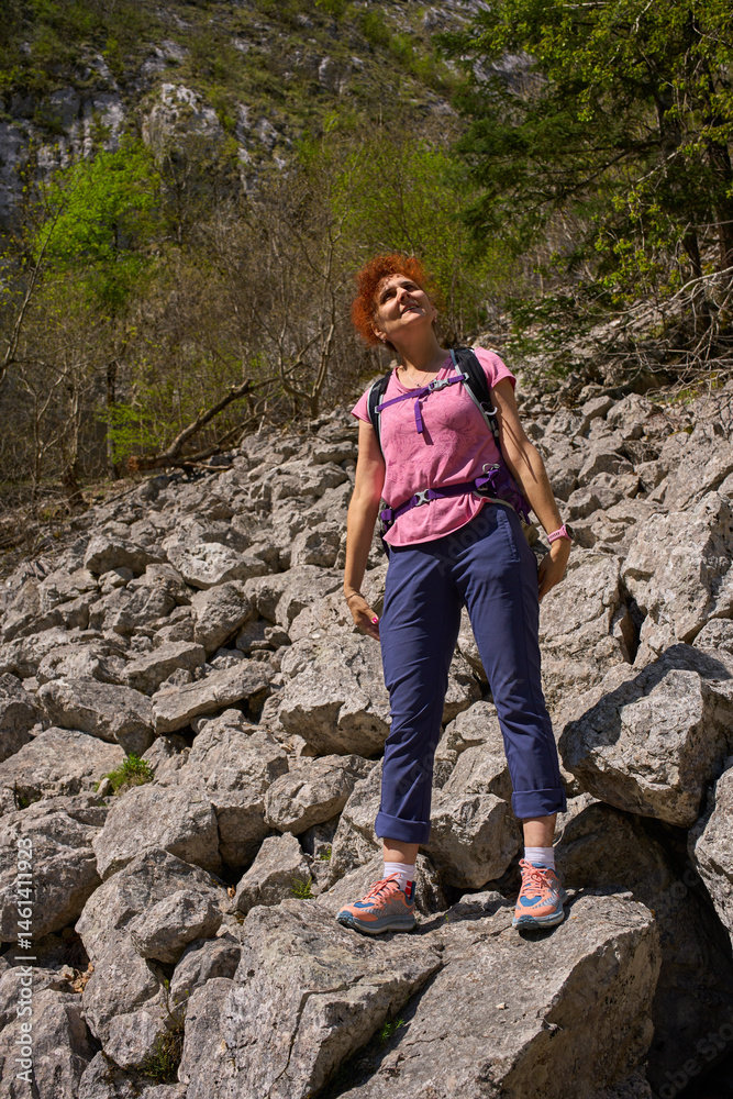 Naklejka premium Woman hiking on rocky hillside