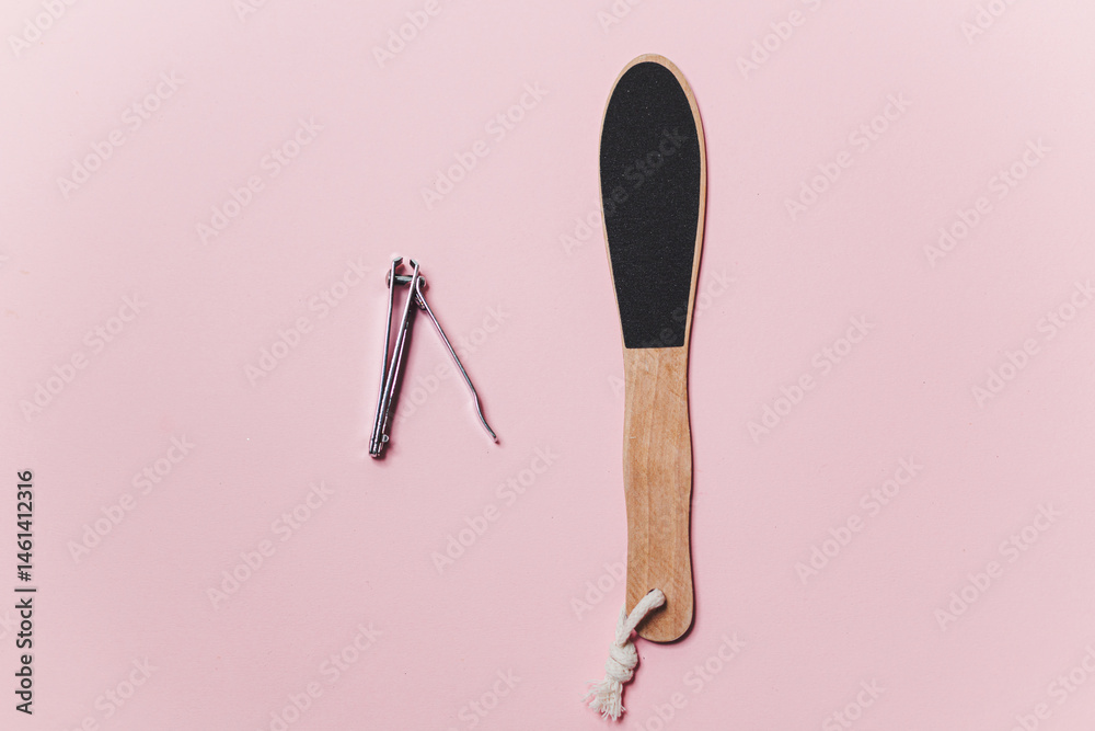 Wooden Heel scraper for foot peeling and steel nail cut on pink. Top view.