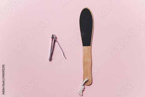 Obraz na płótnie Wooden Heel scraper for foot peeling and steel nail cut on pink. Top view. w salonie