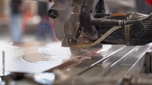 The process of cutting ceramic tiles on a wet saw. Close-up