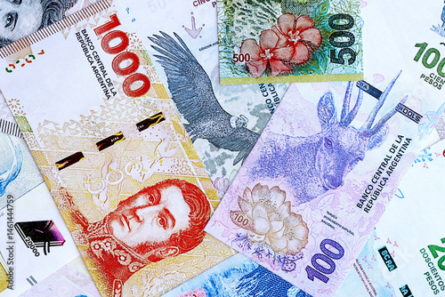 Argentine pesos money bills in big amount lies on white table close up. Finance and banking concept photo