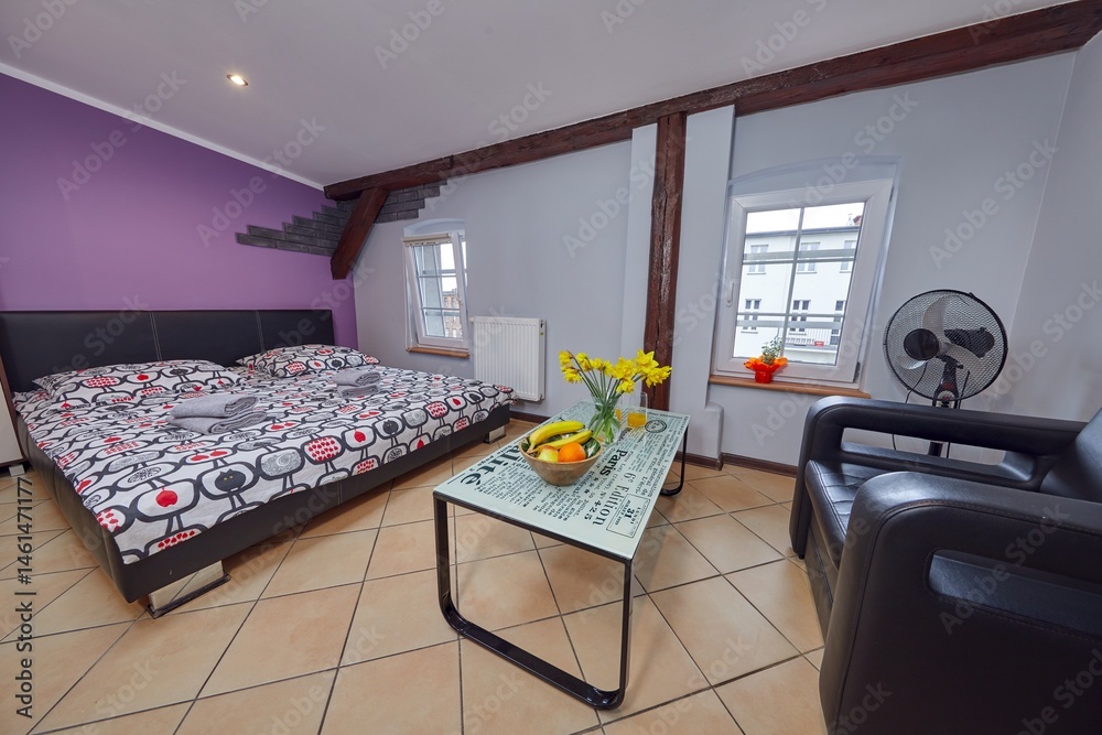 Kolorowy apartament na poddaszu z dużym łóżkiem i aneksem kuchennym