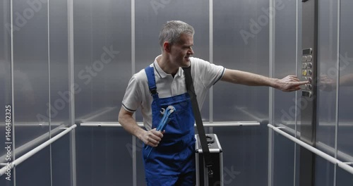 Cheerful plumber dancing and singing in the elevator