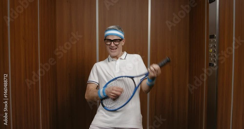 Funny man holding a tennis racket and pretending to play a guitar