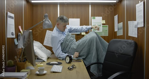 Businessman working and sleeping in his small office