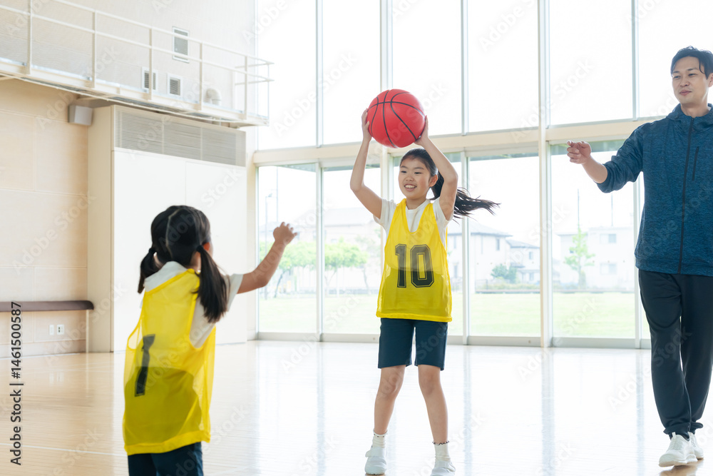 バスケットボールをする子供たちと指導する男性