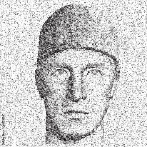 A man wearing a dark hat gazes directly at the viewer.