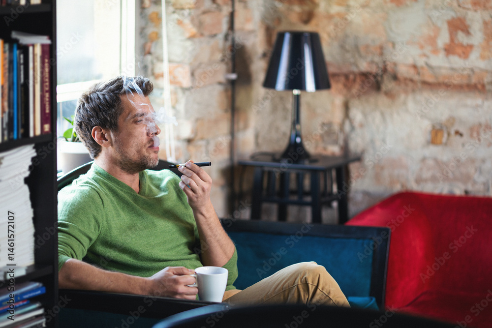 Fototapeta premium Young man using electronic cigarette