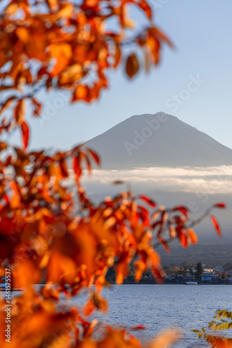 Wallpaper Mural Vertical view of Mount Fuji framed by blurred red autumn leaves. The volcano peak rises above a cloud layer, with Lake Kawaguchi Torontodigital.ca
