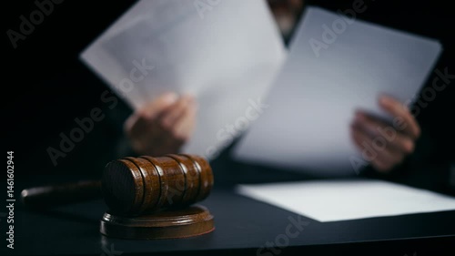 Judge working with legal papers in courtroom, gavel on desk, judicial system