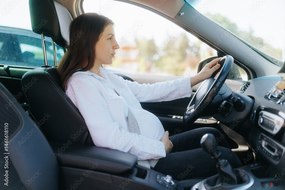 Young pregnant woman driving a car on a sunny day Young pregnant woman driving a car on a sunny day