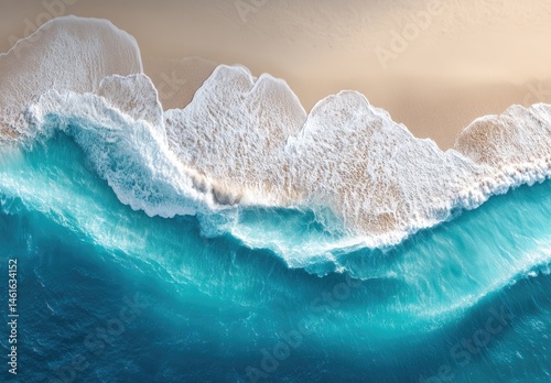 Aerial view of turquoise waves crashing on a beige sandy beach. A vibrant, serene coastal scene. Soft, foamy waves meeting the shore