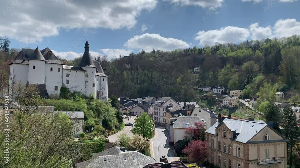 Panoramic, scenic view of Clervaux Castle (Chateau) and Clervaux town houses. People are walking at city centre. Clervaux, Luxembourg