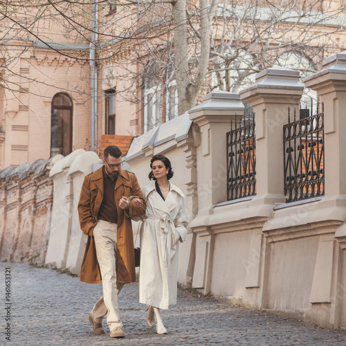 Wallpaper Mural Man and woman dressed in elegant vintage look enjoying each other's company while walking down old street. Concept of joy in motion, retro couple, style, love in everyday moments. Torontodigital.ca