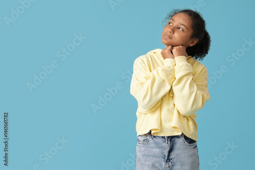 Thoughtful African-American girl on blue background