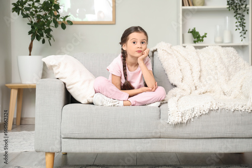 Thoughtful little girl sitt...