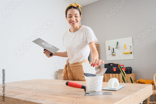 Young woman with putty kniv...