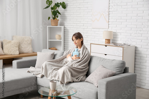 Young woman wrapped in cozy...