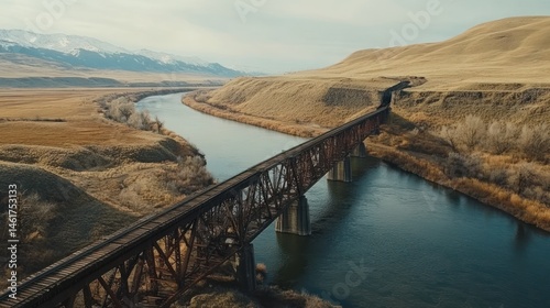 Wallpaper Mural Aerial view of a rusty railroad bridge spanning a river in a mountainous valley. Torontodigital.ca