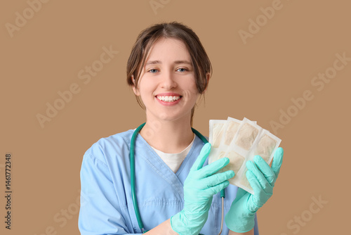 Female doctor with mustard plasters on brown background, closeup