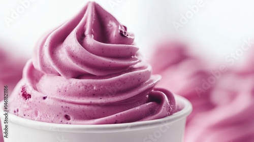 A scoop of blueberry ice cream in a cup, on white