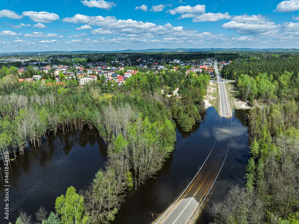 Lake District swallow hole flooded as a result of the mining damage Pomorzany mine in Olkusz,Poland. Aerial drone view of flooded road. Forest submerged in a lake. Sunken sandpit with clear water