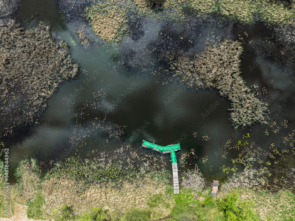 Lake District swallow hole flooded as a result of the mining damage Pomorzany mine in Olkusz,Poland. Aerial drone view of flooded road. Forest submerged in a lake. Sunken sandpit with clear water