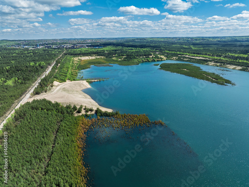 Obraz na płótnie Lake District swallow hole flooded as a result of the mining damage Pomorzany mine in Olkusz,Poland. Aerial drone view of flooded sand pit. Forest submerged in a lake. Sunken sandpit with clear water w salonie